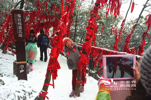 鬼谷棧道上掛滿祈愿帶的“紅樹林”在白雪中分外妖嬈，吸引游人拍照 丁云娟攝_副本.jpg